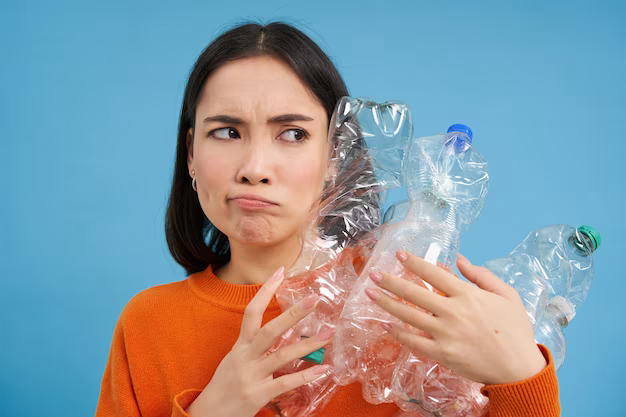 A girl holds several plastic bottles in her hands